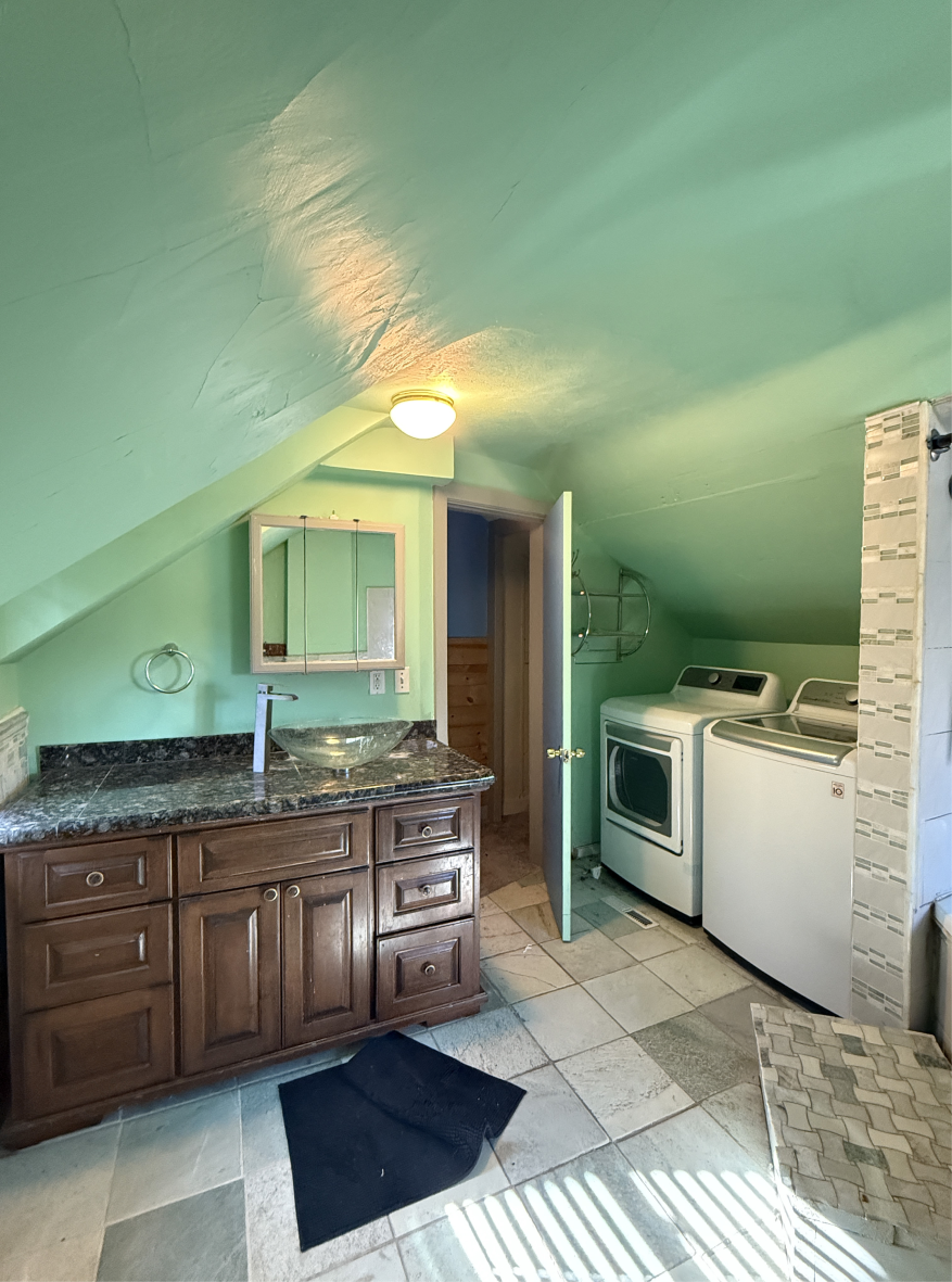 Outdated bathroom with green walls and dark vanity, before remodel
